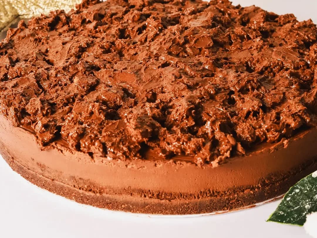 Torta inteira com cobertura cremosa e rústica, em tom de chocolate